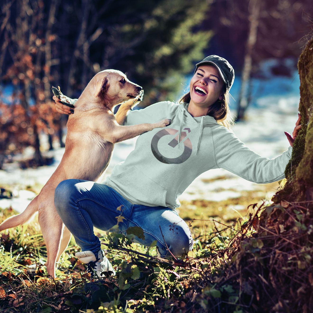 Frau mit Hoodie und Hund bei einem Waldspaziergang