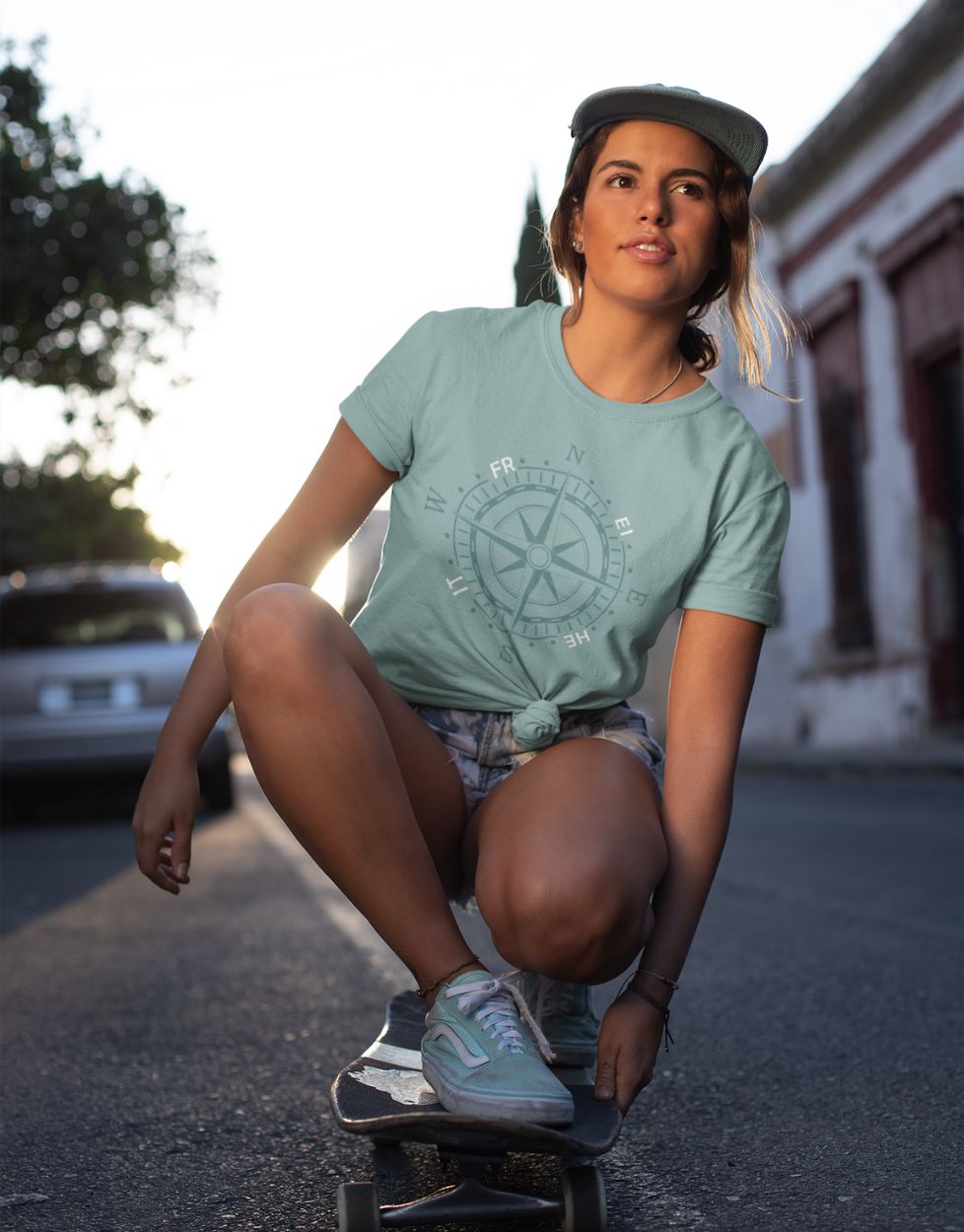 Unisex T-Shirt in Türkis mit maritimer Kompassrose in abgestimmten Farben, frischer Küsten-Look für Sommer und Freizeit Modell Mädchen auf Longboard